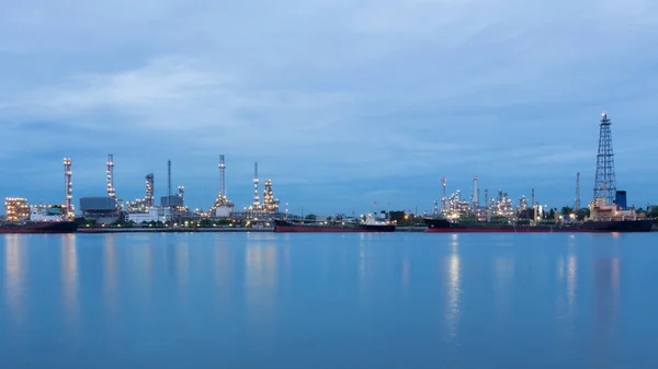 Refinería industrial de petróleo frente al río — Foto de Stock