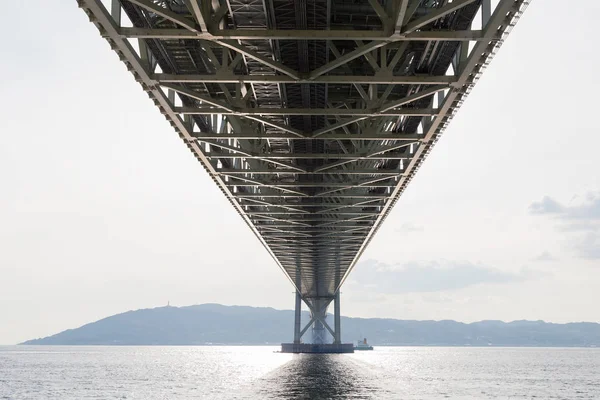 Под мостом Акаси Кайкё, самым длинным подвесным мостом, в порту Кобе — стоковое фото