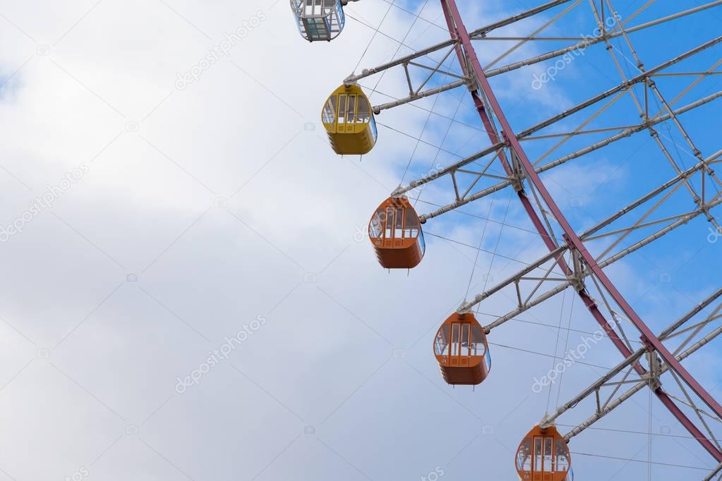 Close up funfair ferris wheel with cloudy sky