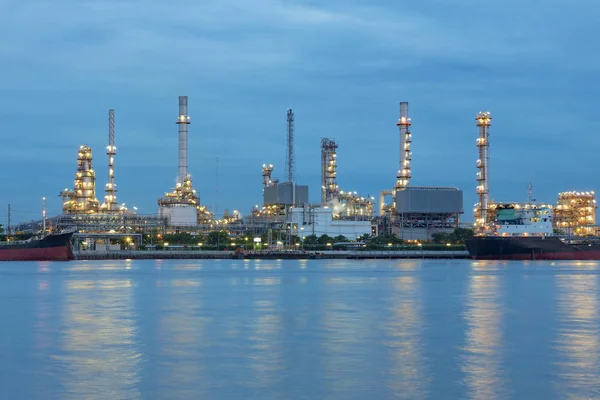 Crepúsculo Planta de refinería de petróleo frente al agua horizonte vista nocturna — Foto de Stock