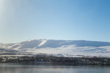 Kar dağ üzerine açık mavi gökyüzü arka plan ile küçük bir köy
