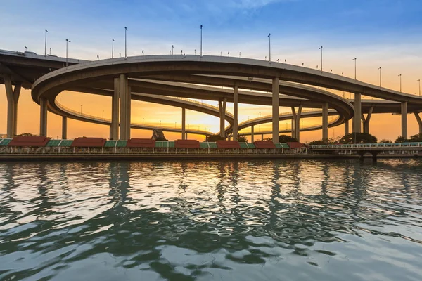 Sunset over round highway intersection river front — Stock Photo, Image