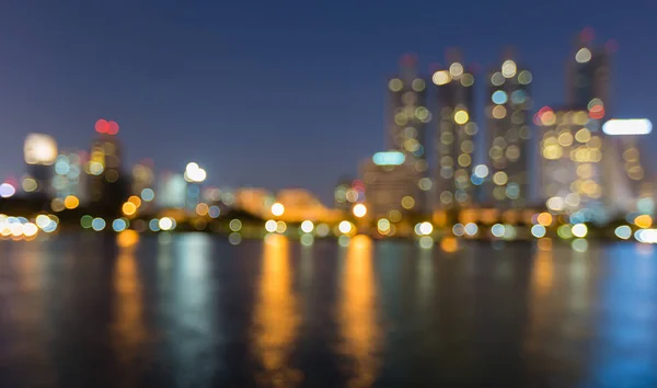 Crepuscolo notte offuscata bokeh luce edificio per uffici con riflesso dell'acqua — Foto Stock