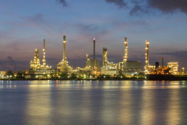 Alacakaranlık gökyüzü ile gece görünümü petrol rafinerisi ışık su ön 