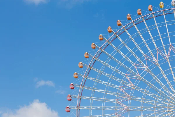 Büyük dönme dolap ile yolunu açık mavi gökyüzü 