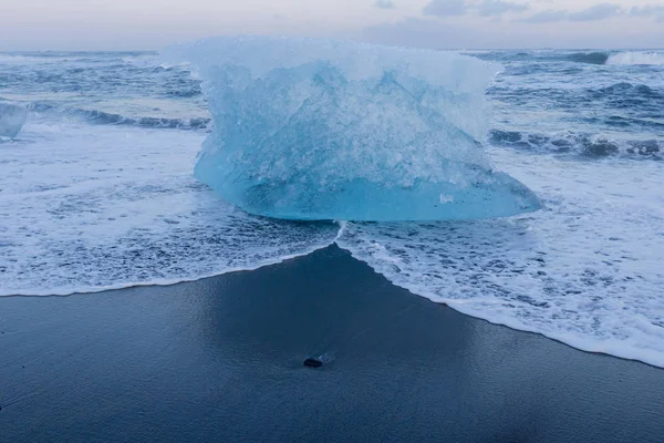 Rompere il ghiaccio dal ghiacciaio sulla spiaggia di sabbia nera — Foto Stock