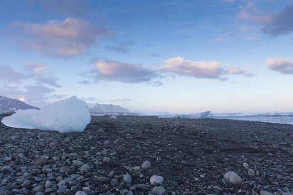 Glace sur petite plage de sable et de roche noire — Photo