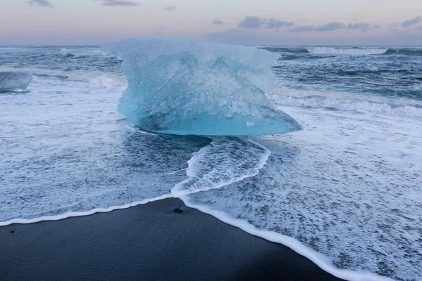 Gletsjerijs breken op zwarte zand strand, IJsland — Stockfoto