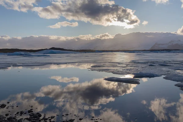 Reflectie water seizoen lagune met zonsondergang achter wolk, IJsland — Stockfoto