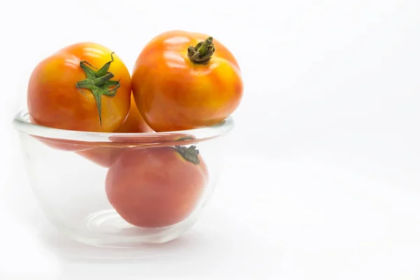 Tomate fresco en taza de vidrio, sobre blanco — Foto de Stock