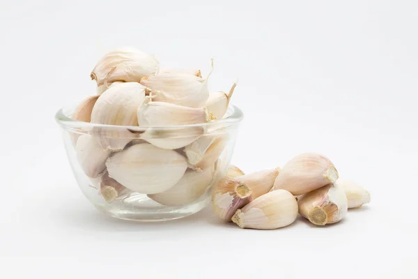Glass cup of fresh root garlic on white — Stock Photo, Image