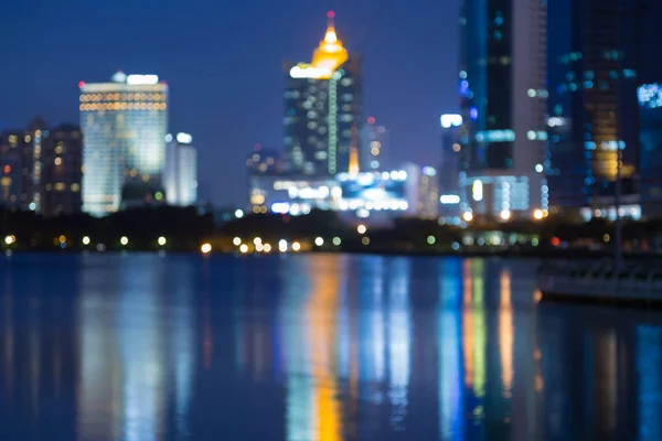 Blurred bokeh light office building downtown with water reflection — Stock Photo, Image