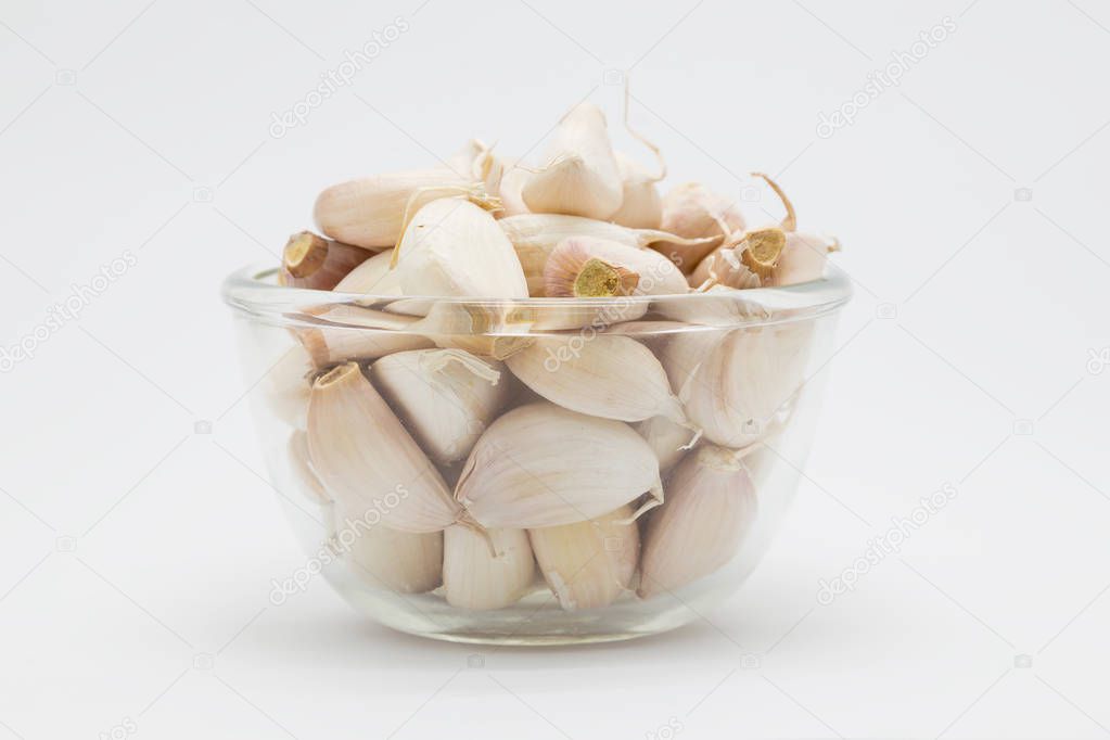 Fresh garlic in glass cup on white 