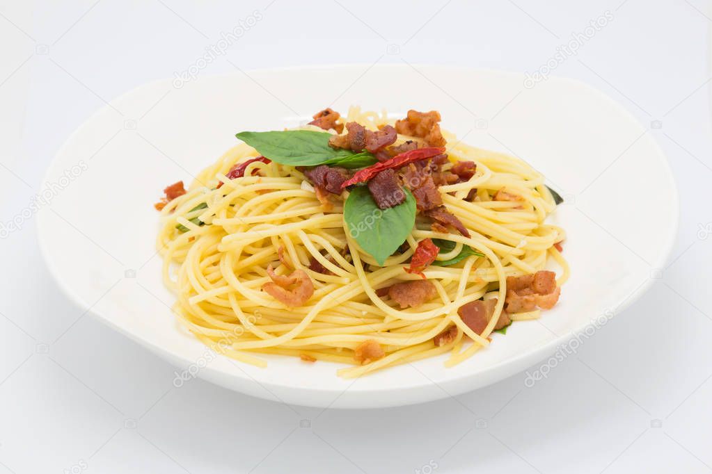 Homemade bacon basil spaghetti on white 