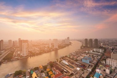 Gün batımı ile nehir eğri manzarası üzerinden şehir şehir havadan görünümü 