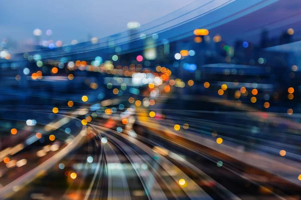 Böjd rörelse tågspåren över staden natt suddig bokeh ljus — Stockfoto