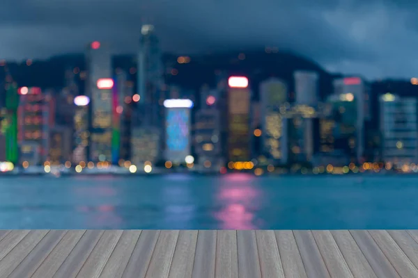 Opening wooden floor, City night blurred bokeh light Hong Kong business downtown, abstract background