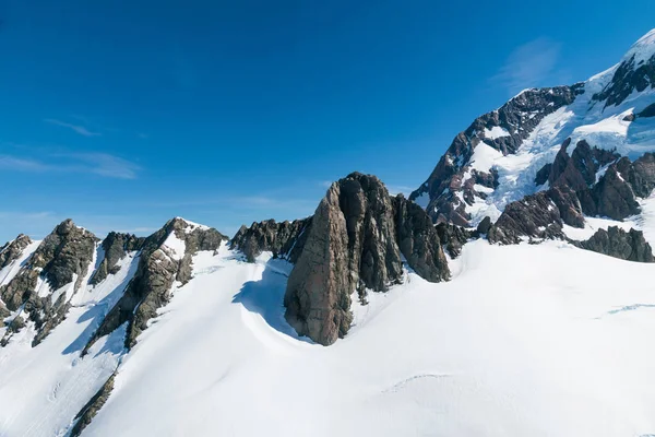 上から見る岩山雪 ニュージーランドの自然の風景の背景に青い空を背景 — ストック写真