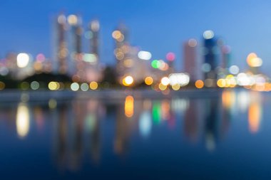 Gece ışık şehri alacakaranlıkta, arka plan yansıması ile bina defocused