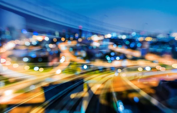 Curved train track over night light blurred bokeh city downtown, abstract background
