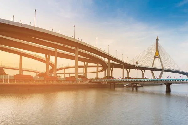 Puesta de sol sobre puente colgante e interconexión de carretera río — Foto de Stock