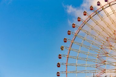 Dev dönme dolap mavi gökyüzü ve bir eğlence parkı, yani beyaz bulut karşı yakın çekim