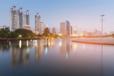 Akşam alacakaranlık ofis binası Şehir Parkı su yansıması üzerinde