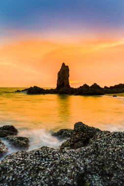 Sahil rock sahilde, doğal peyzaj arka plan üzerinde gökyüzü günbatımı