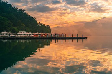 Güneş Ay Gölü 'ndeki tekne iskelesinde su yansıması ve Tayvan doğal manzarası olan güzel bir gökyüzü.