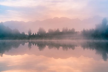 Ayna suyunda sis Yeni Zelanda 'da Matheson Gölü' nde pişiyor.