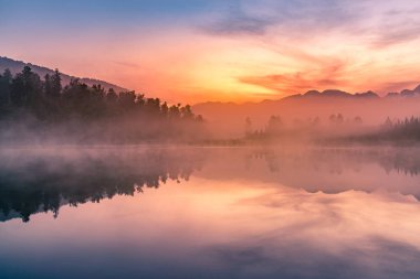 Matheson Gölü, güzellik yansıması ile gündoğumu gökyüzü arka planı, Yeni Zelanda doğal manzarası