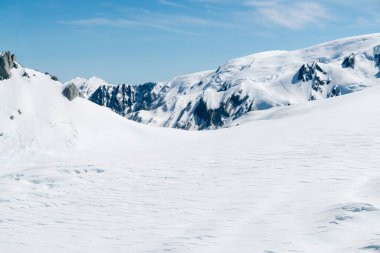 Beyaz, temiz kar kaplı, siyah kaya dağı, doğal manzara.