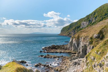 Kaya dağının üzerinden deniz kıyısı silüeti, doğal manzara