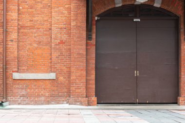 Kırmızı tuğla duvar, kahverengi büyük kapı klasik tarzı. 