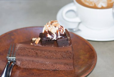 Tabakta çikolatalı kek ve bir fincan kahve.