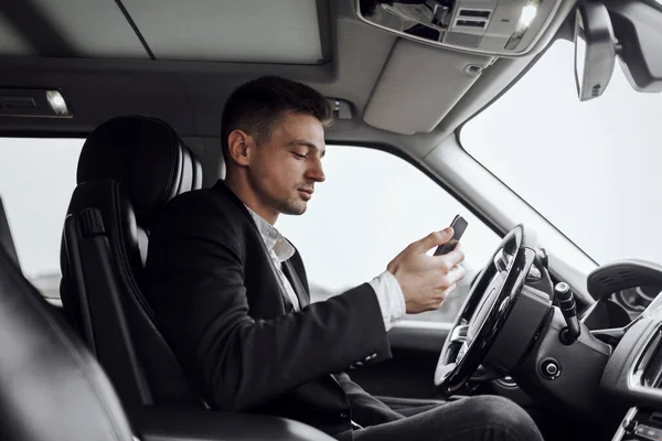 Beau homme d'affaires utilise le téléphone portable dans l'automobile — Photo