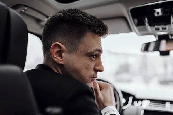 Yakışıklı iş adamı modern otomobilde dinleniyor.