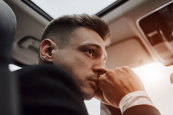 Handsome businessman behind the wheel during sunny day