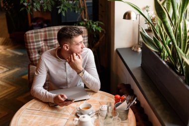 Genç adam kahve dükkanında dinleniyor.