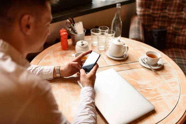 Guapo caucásico chico usando teléfono inteligente en la cafetería — Foto de Stock