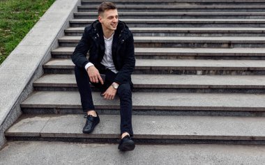 Mutlu yakışıklı adam dışarıda dinleniyor.