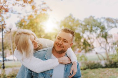 Mutlu çiftin portresi gülerken sonbahar parkında güzel anlar yaşıyor.