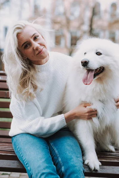 Young Smiling Woman Hugging Her White Fluffy Dog While Sitting — Stock Photo, Image