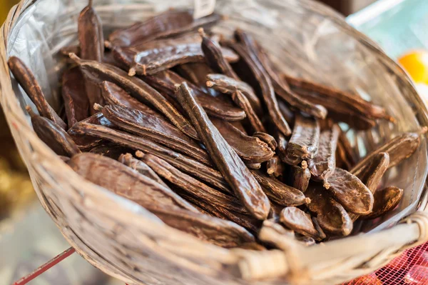 Vainas de algarroba en canasta de mimbre . —  Fotos de Stock