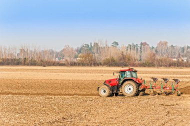 sonbaharda plowing kırmızı traktör.