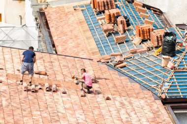 Construction site. Masons to work on the roof for laying tiles clipart