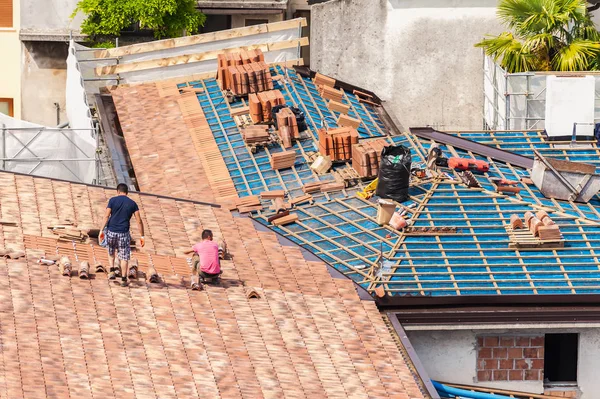 Lugar de construcción. Albañiles para trabajar en el techo para la colocación de baldosas — Foto de Stock