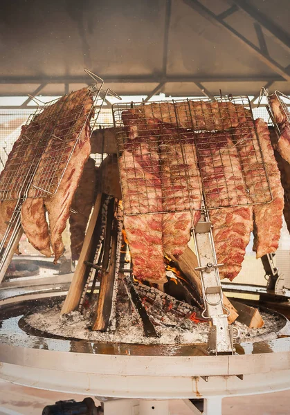 Roasted meat of beef cooked on a vertical grills. — Stock Photo, Image