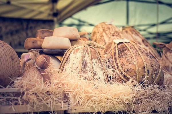 Cheeses and cut pieces on sale at market. — Stock Photo, Image