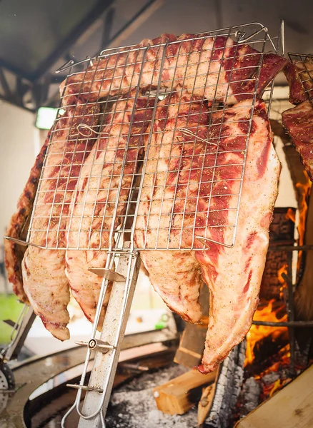 Roasted meat of beef cooked on a vertical grills. — Stock Photo, Image